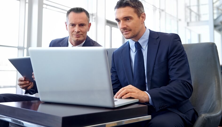 Two men looking at a laptop